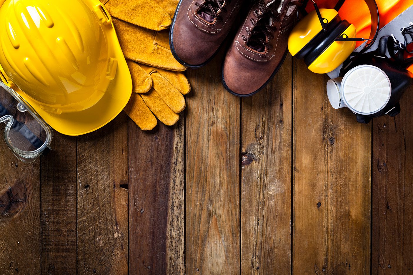 Yellow safety gear and boots on wood